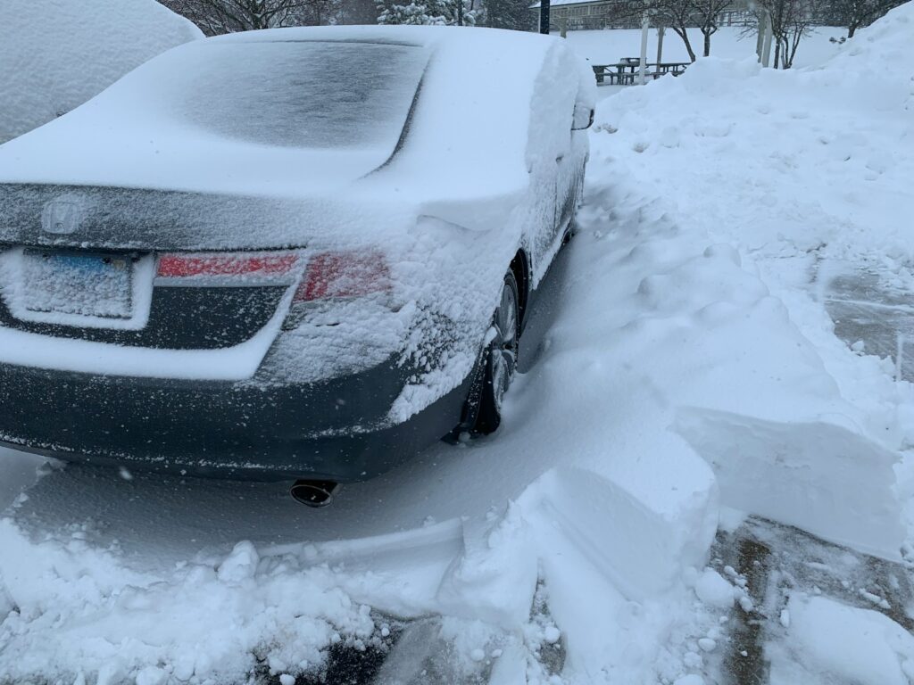 Car covered in deep snow after a blizzard.