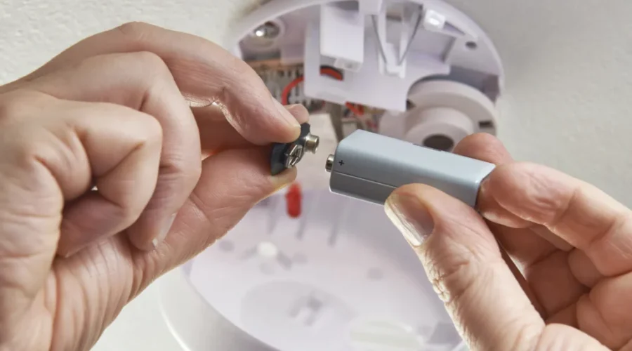Close Up Of Replacing Battery In Domestic Smoke Alarm New provincial rules for carbon monoxide alarms take effect in January