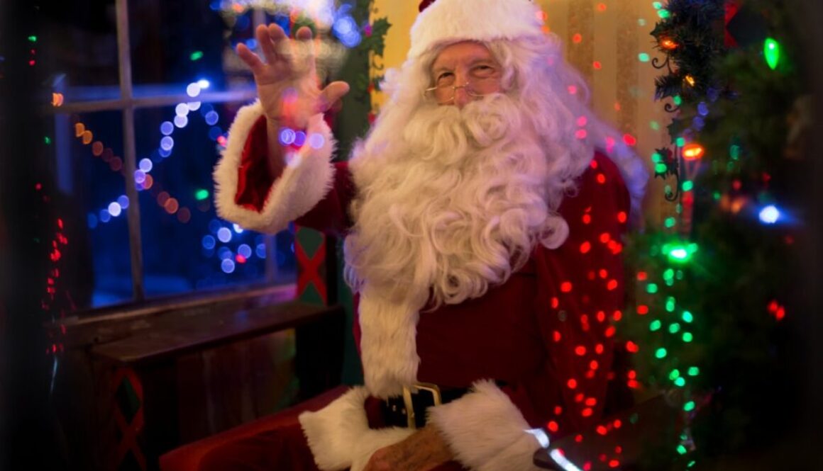 santa claus sitting beside lit tree