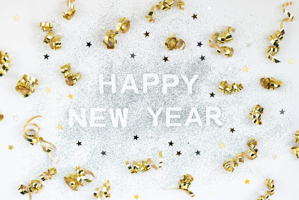 A happy new year card with gold bells and confetti