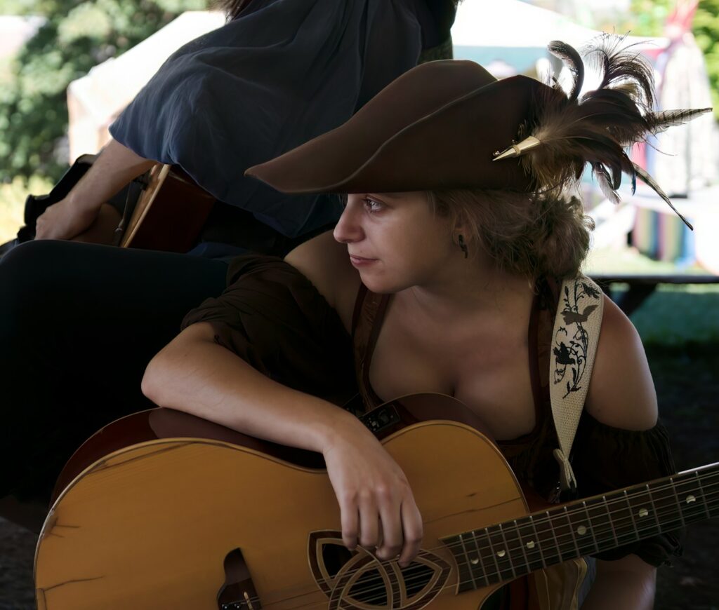 A woman in a cowboy hat playing a guitar