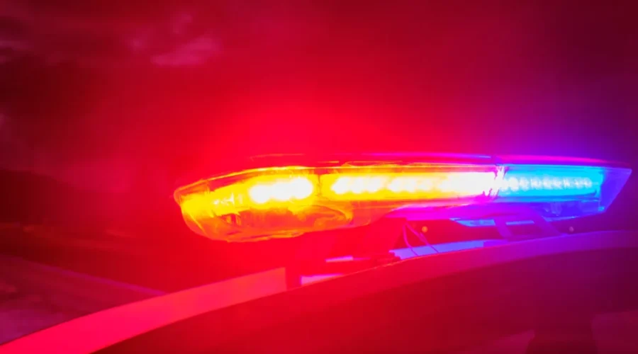 police car flashing lights in the night selective focus Third person charged in ongoing sex trafficking investigation